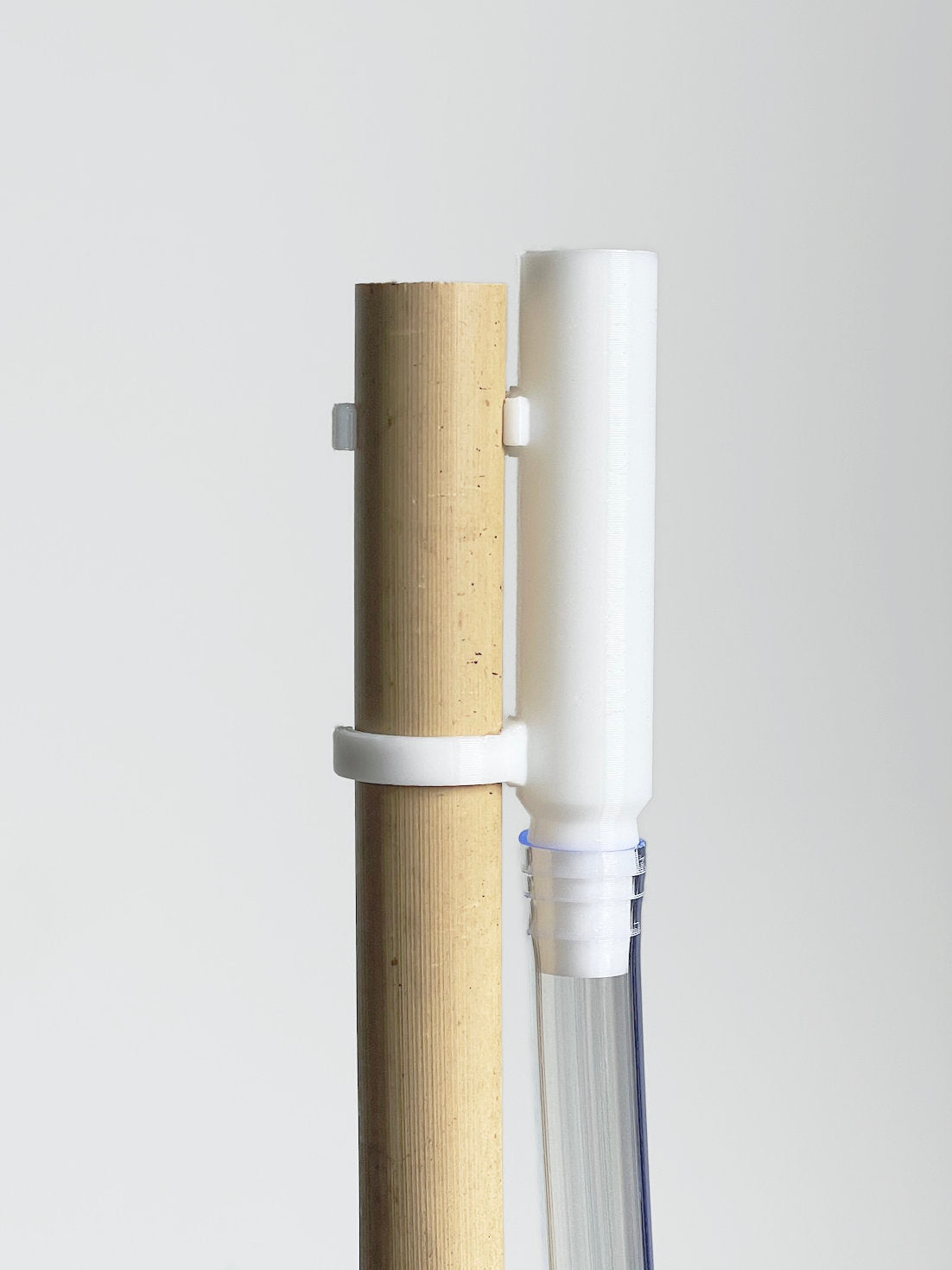 Produktaufnahme: Holz- und Kunststoffröhren, weiße Halterungen.