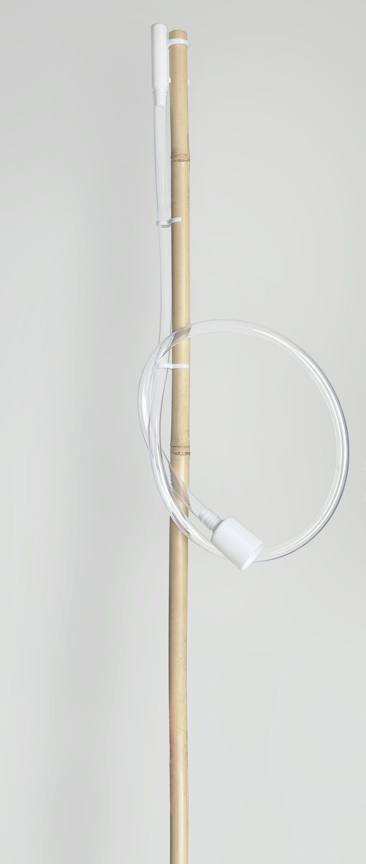 Bambusstange, durchsichtiger Schlauch, weiße Halterungen.